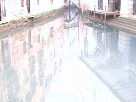In the afternoon the still canal waters reflect Venetian images.
